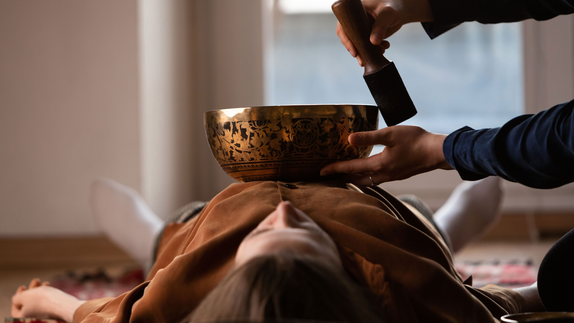 Assortment of culinary herbs and spices arranged in a circle, including cinnamon, ginger, turmeric, and rosemary, with a mortar and pestle.