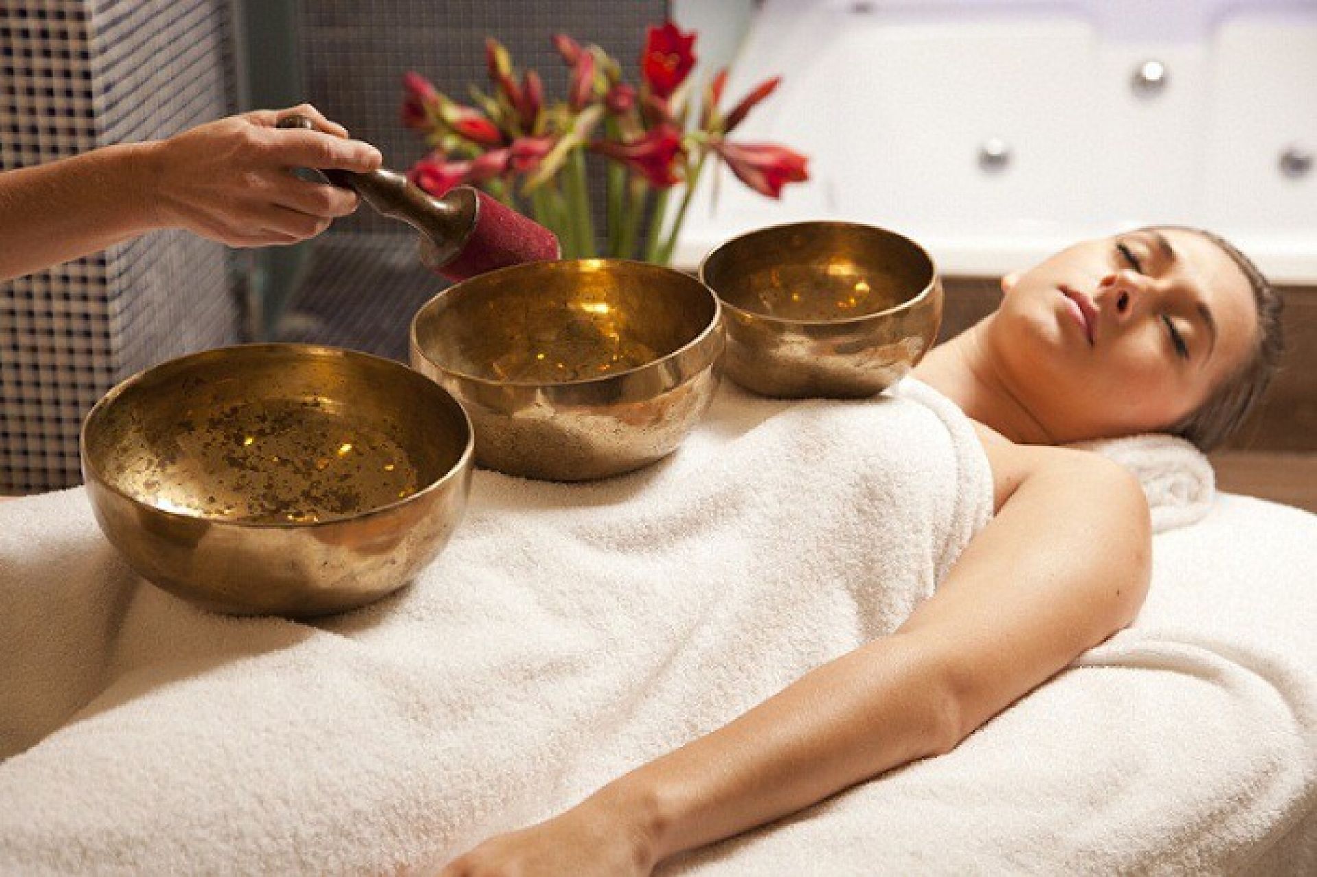 Assortment of culinary herbs and spices arranged in a circle, including cinnamon, ginger, turmeric, and rosemary, with a mortar and pestle.