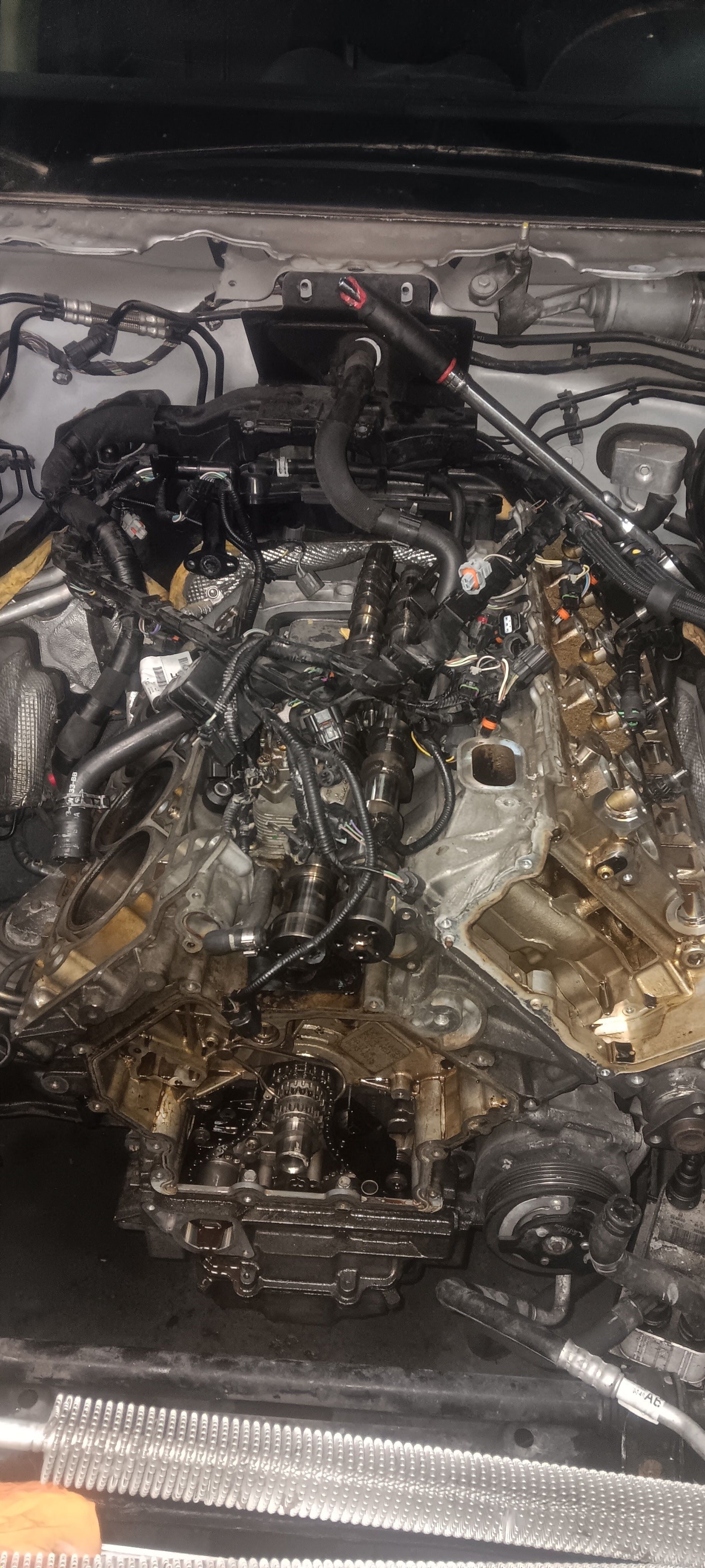 A close up of a car engine with a lot of wires coming out of it.