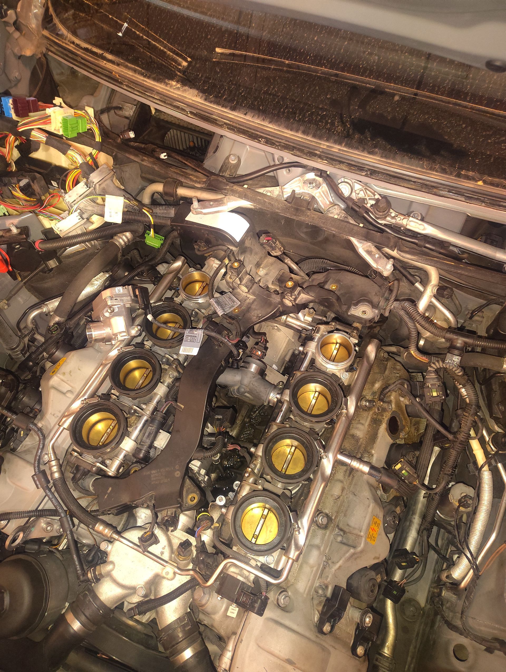 A close up of a car engine with the hood open.