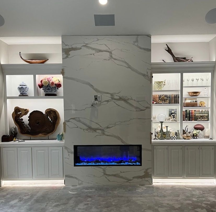 Luxury marble electric fireplace installation with blue flame display and shelving.