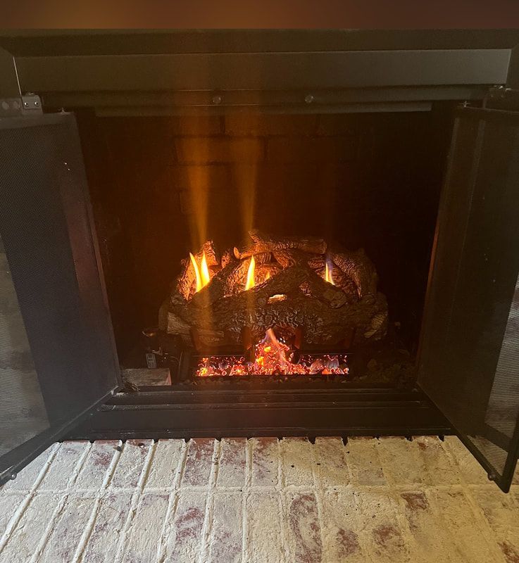 Cozy indoor gas fireplace installation with glowing flames and brick surround.