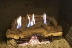 Gas fireplace with realistic logs after professional chimney cleaning service.