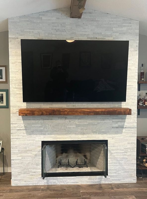 Contemporary fireplace remodel with mounted TV and white brick surround.