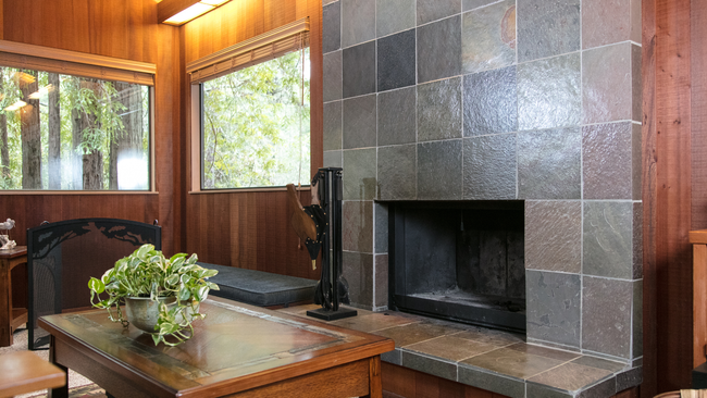 A living room with a fireplace and a wooden table.