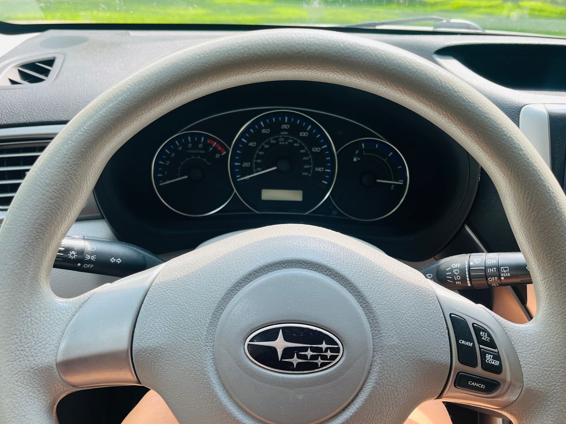 Close-up of a Subaru steering wheel with the dashboard visible in the background. 