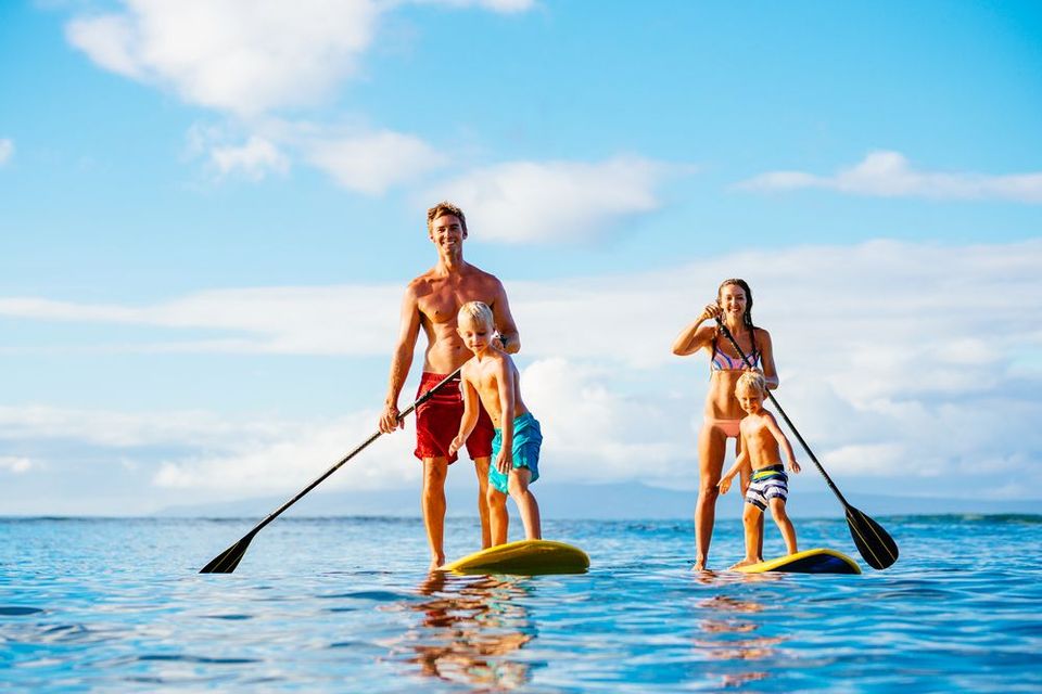 A family is paddle boarding in the ocean.