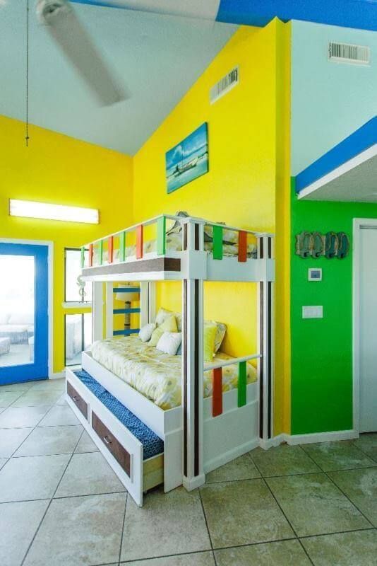A bunk bed in a room with yellow and green walls