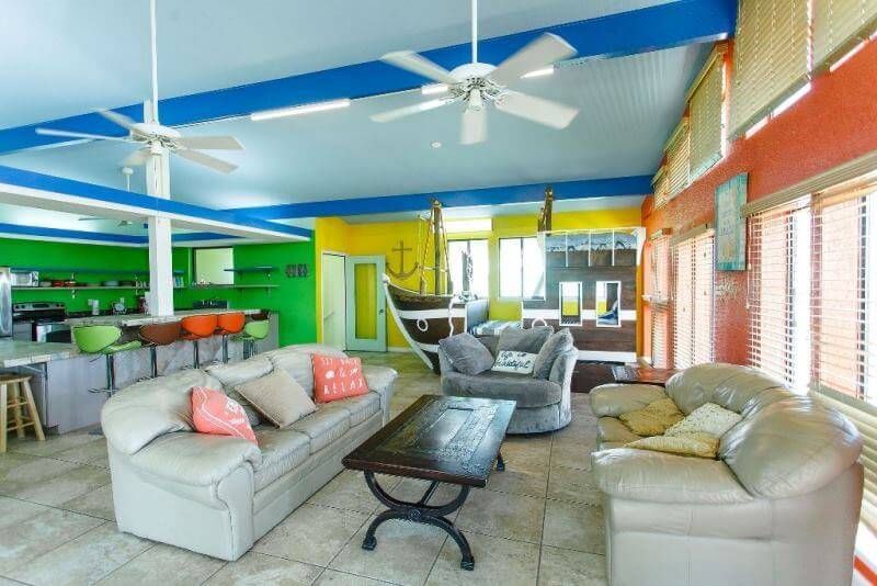 A living room with a lot of furniture and a ceiling fan