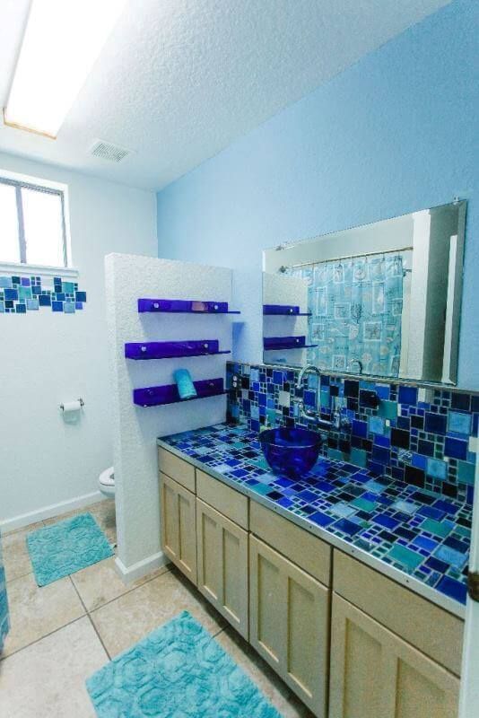A bathroom with blue tiles and a sink