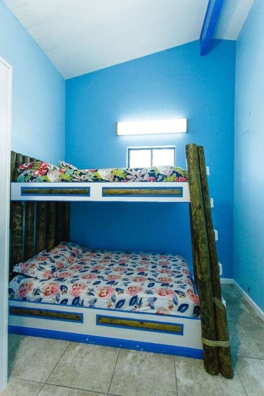 A bunk bed in a room with blue walls