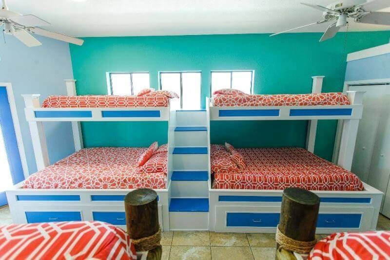 A bedroom with three bunk beds and a ceiling fan