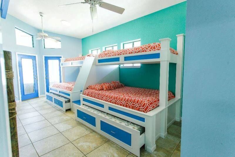 A bedroom with three bunk beds and a ceiling fan.