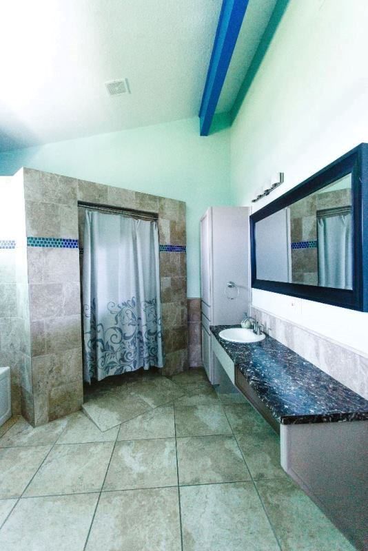 A bathroom with a sink a mirror and a shower curtain