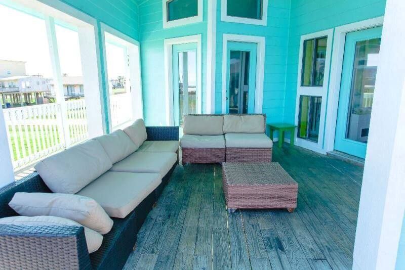 A screened in porch with a couch , chairs , and a table.
