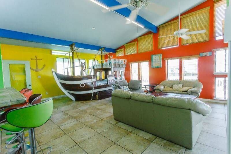 A living room with a pirate ship on the wall.