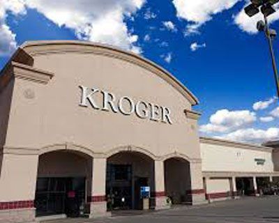 The front of a kroger grocery store with a blue sky in the background.