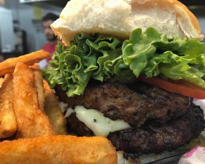 A close up of a hamburger and french fries on a plate.