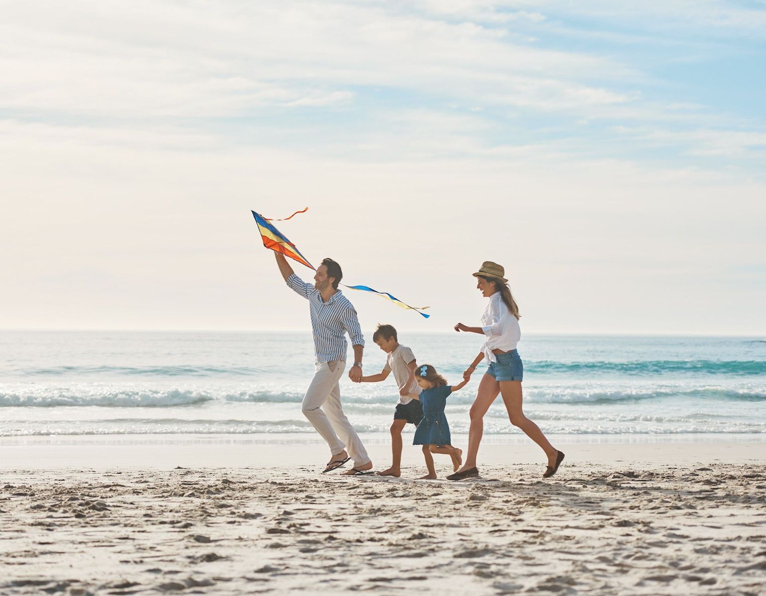 A family is flying a kite on the beach.