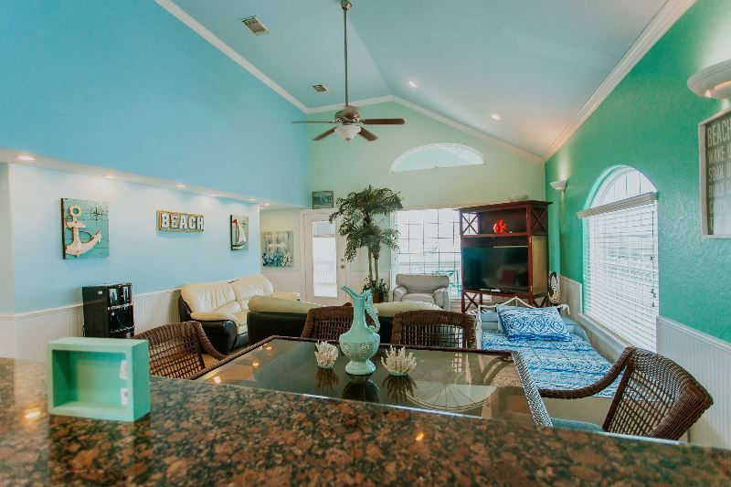 A living room with a table and chairs and a ceiling fan.
