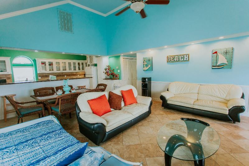 A living room with two couches , a table and a ceiling fan.