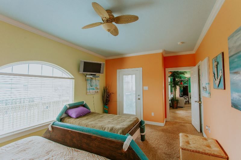 A bedroom with two beds and a ceiling fan.