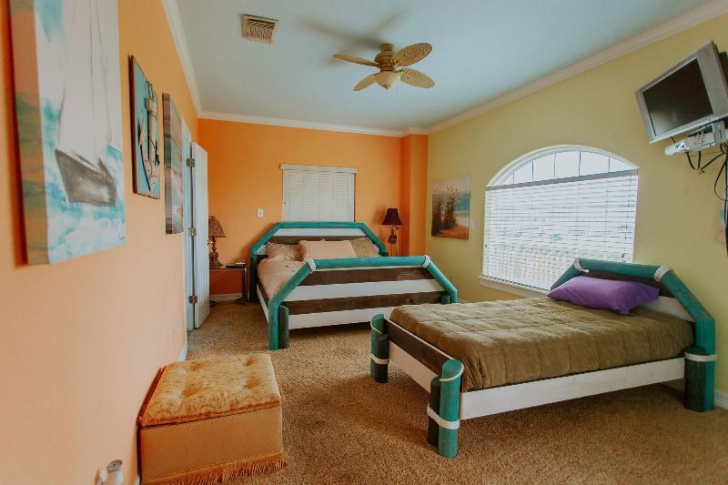 A bedroom with two beds and a ceiling fan.