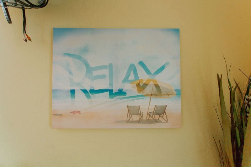 A painting of a beach scene with the word relax written on it.