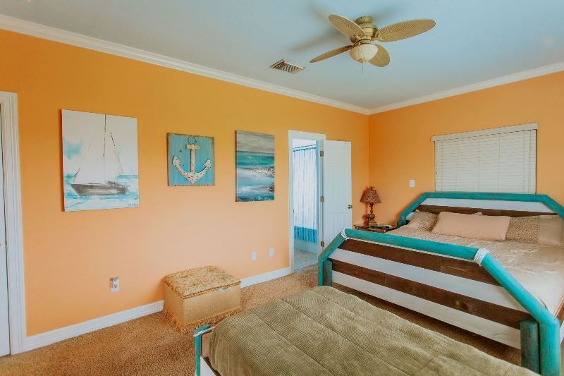 A bedroom with two beds and a ceiling fan.