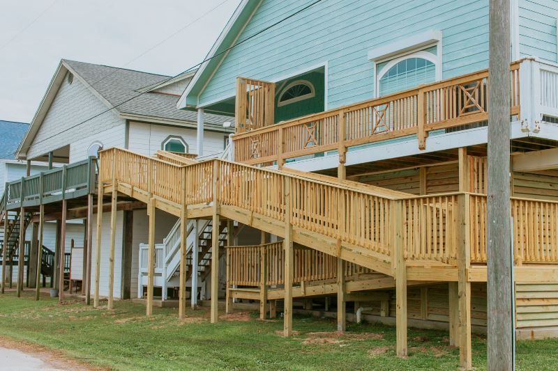 A house with a wooden deck and stairs leading up to it.