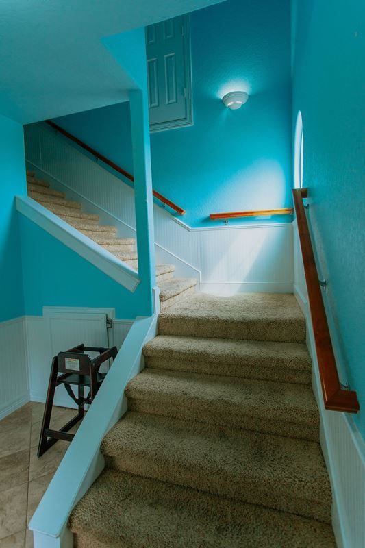 A set of stairs leading up to the second floor of a house with blue walls.