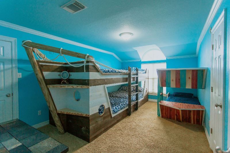 A bedroom with a bunk bed in the shape of a pirate ship.