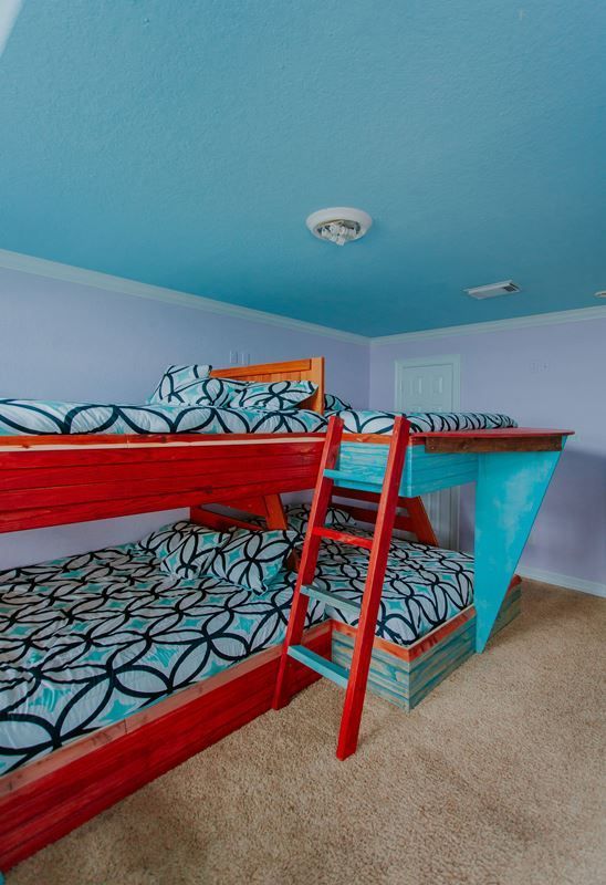 A bedroom with two bunk beds and a blue ceiling.