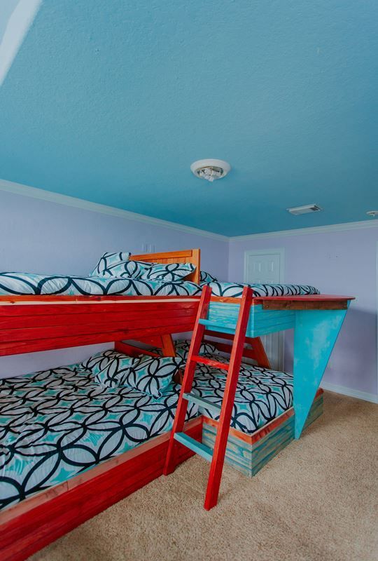 A bedroom with bunk beds and a blue ceiling