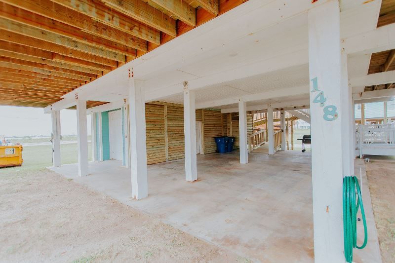 A building under construction with a lot of pillars and a green hose.
