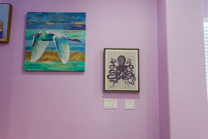There are two paintings on the wall , one of which is of an octopus.