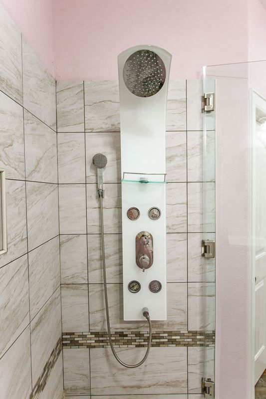 A bathroom with a shower head and a glass door.