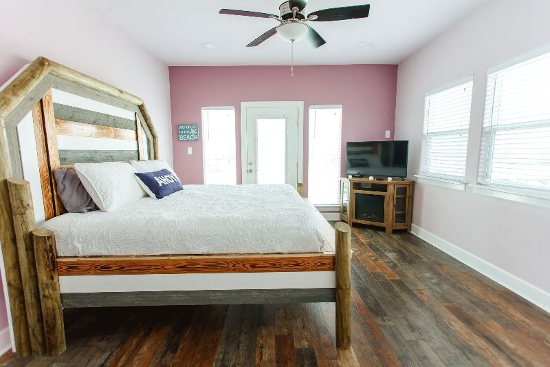 A bedroom with a bed , television , and ceiling fan.