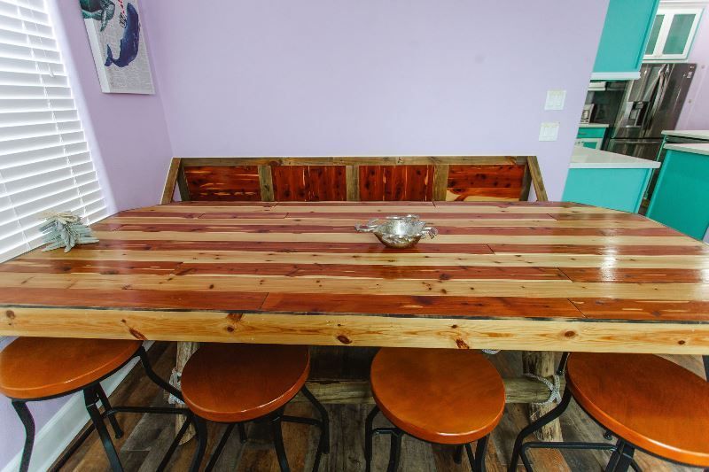 A wooden table with stools and a bench in a dining room.