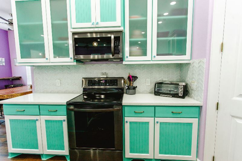 A kitchen with a stove , microwave , and toaster oven.