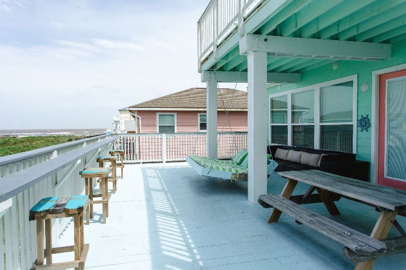 There is a large deck with a picnic table and chairs on it.