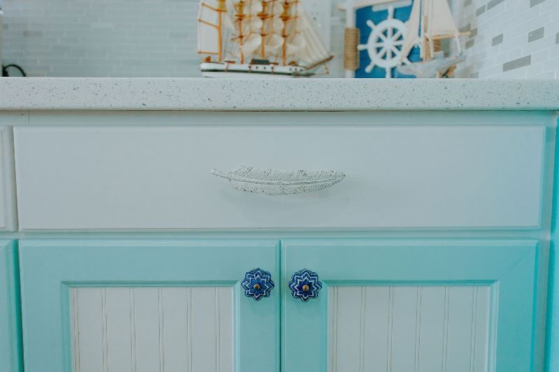 A close up of a blue and white cabinet with blue handles.