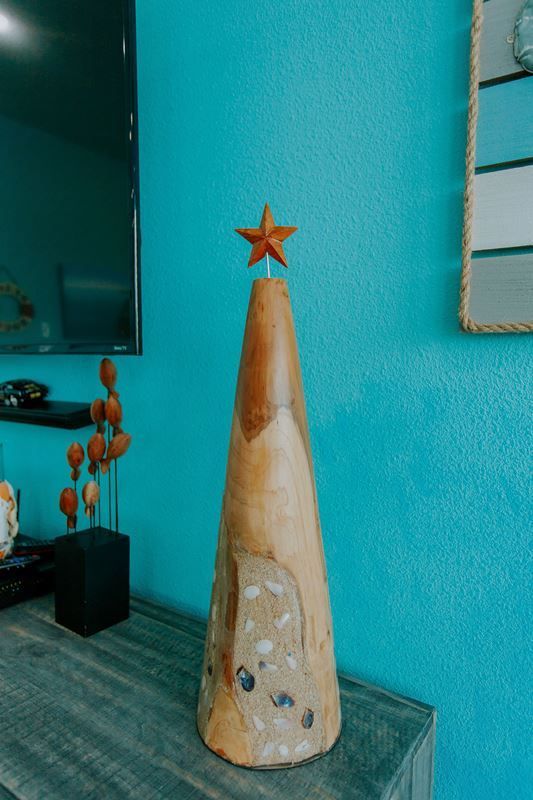 A wooden christmas tree with a star on top is sitting on a wooden table.