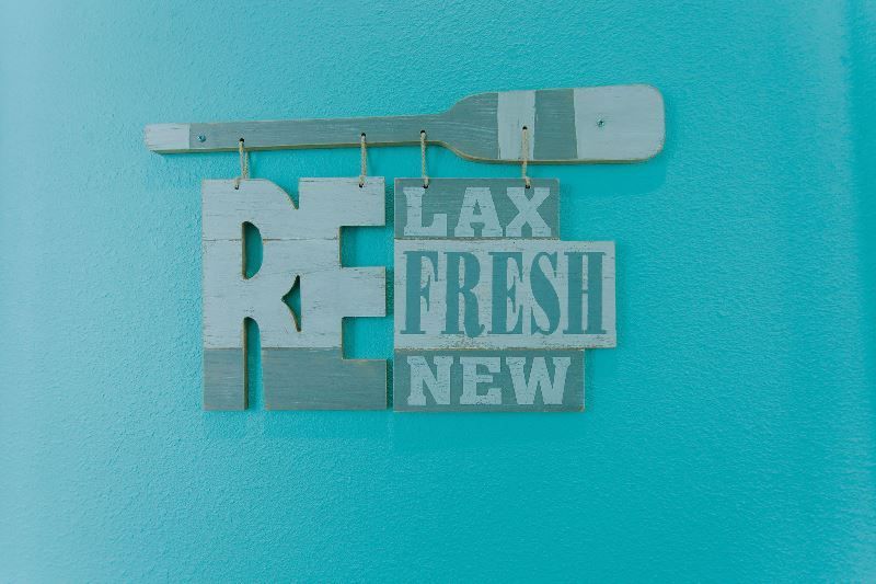A sign that says `` lax refresh new '' is hanging on a blue wall.