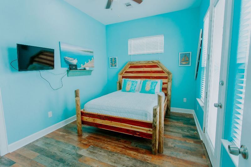 A bedroom with a bed , television , and blue walls.