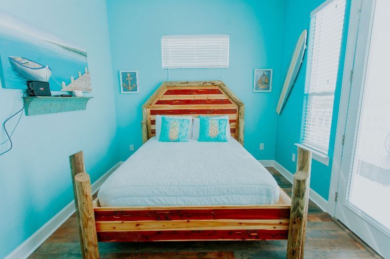 A bedroom with blue walls and a wooden bed.