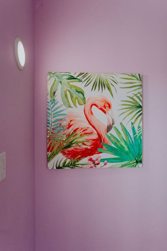 There is a painting of a flamingo on the wall.
