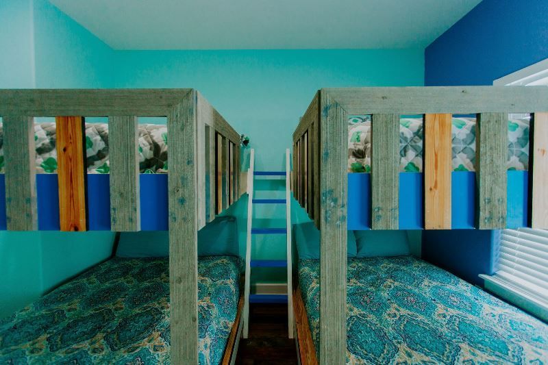 A bedroom with three bunk beds and a ladder.
