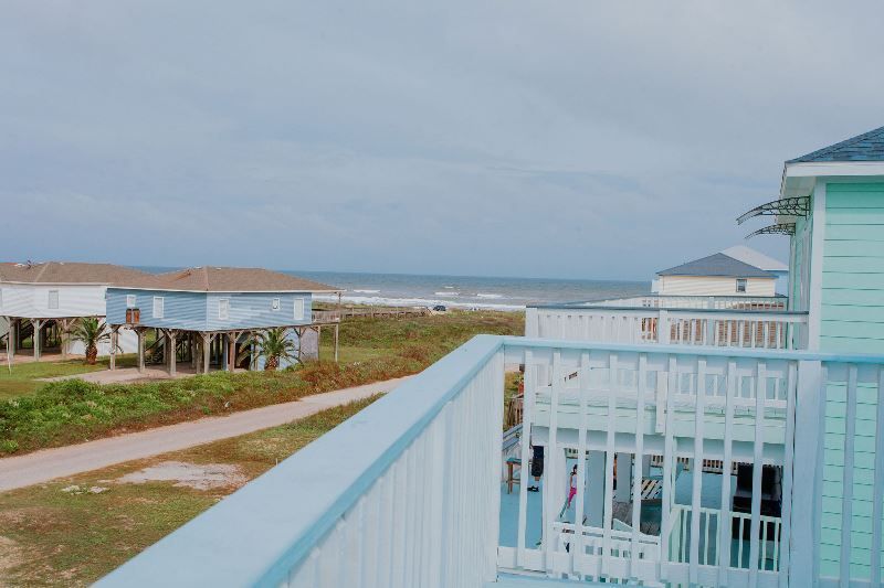 A view of the ocean from a balcony of a house.