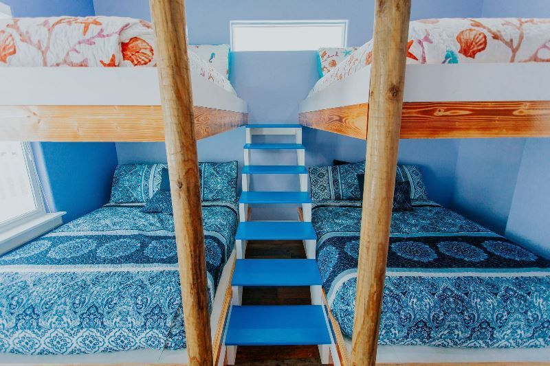 A bunk bed with stairs leading up to it in a room.